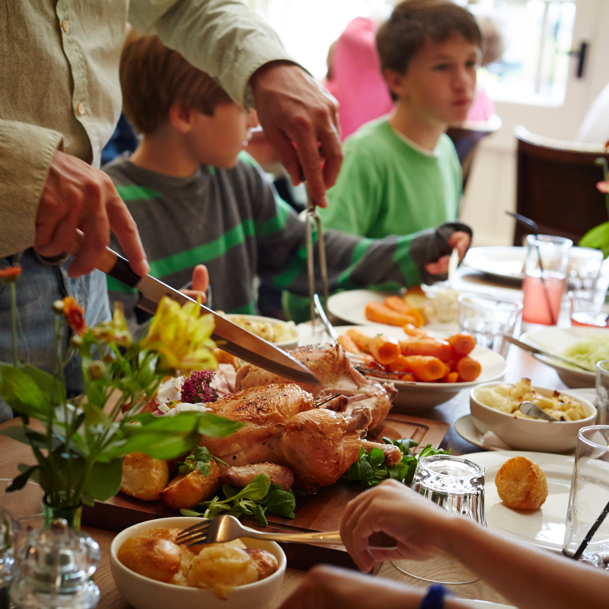 Families enjoying a meal at The King's Head Inn, a child friendly pub in Bledington, Cotswolds